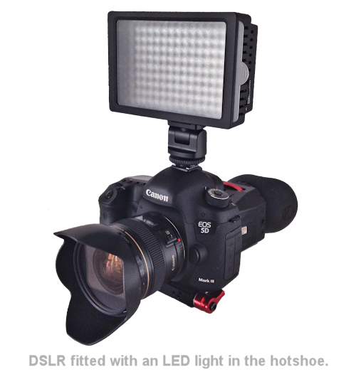 a dslr camera with an led light in the hotshoe.